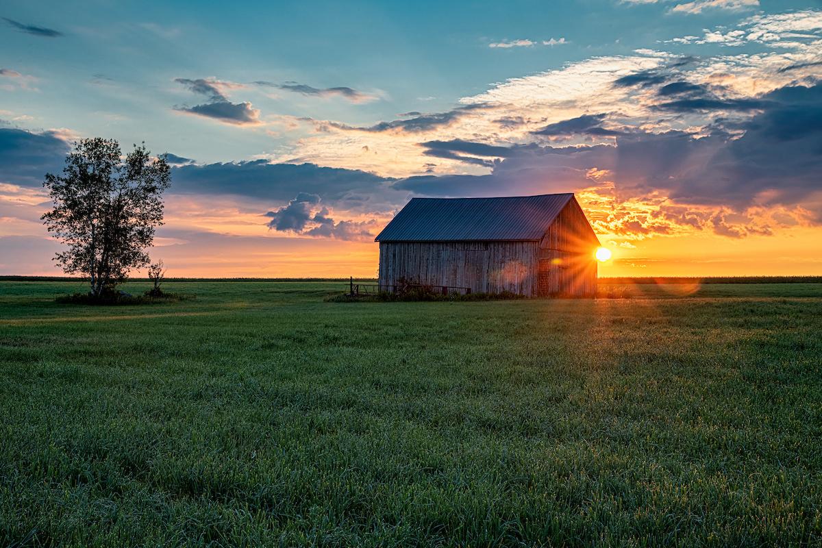 Barn with sunset in the background by John DiGiacomo